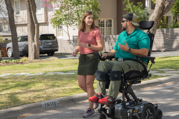 A wheelchair user and his partner running 